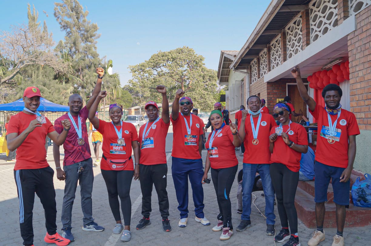 St. Cecilia Choir community members celebrating together after a fundraising run with medals and raised fists