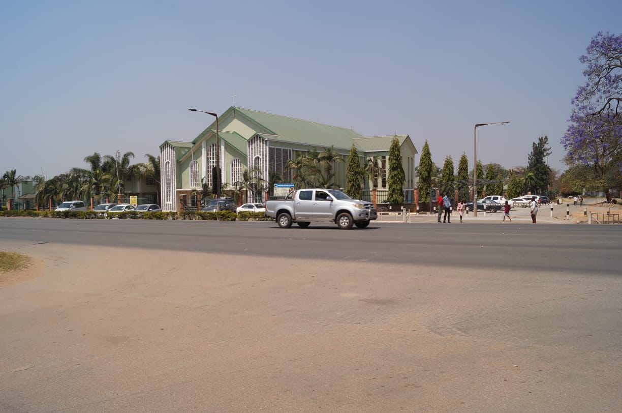Panoramic view of Cathedral of Christ the King, Ndola with palm trees and surrounding grounds