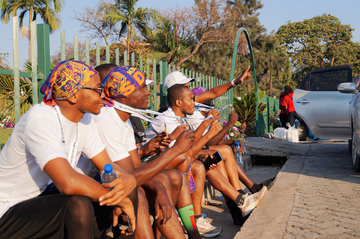 Young runners relaxing and bonding after the race, holding their medals with colorful headbands